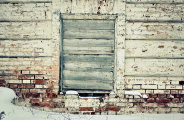 old brick wall in the center of the window, laid nailed old boards