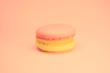 Yellow and red macaroon cake on pink background bright food photography