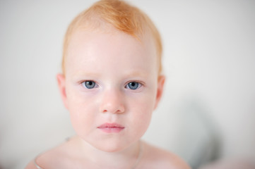 Portrait of a redheaded baby on the white background