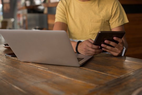 Man using digital tablet in cafeteria