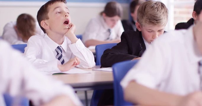4k Bored school boy day dreaming during a class.Slow motion