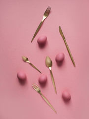 Still life photo of lots of pink easter eggs and flatware