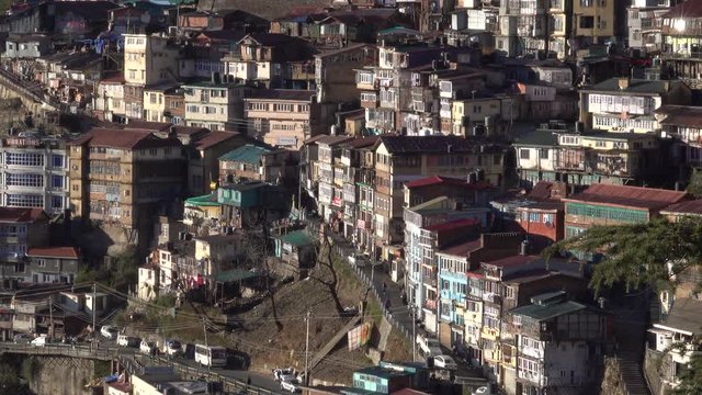 Old buildings and pedestrians on steep roads of the inner city in Shimla, India 