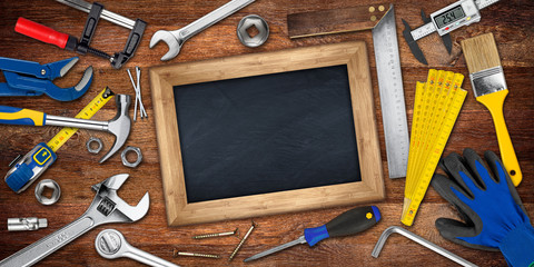 hand tools and empty blackboard chalkboard with copy space on wooden workshop table / werkzeug und...