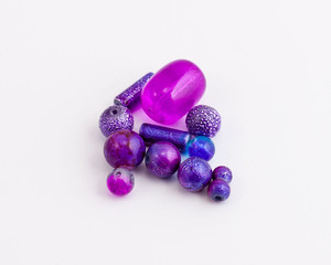 dozen purple beads of different shapes used to create jewelry