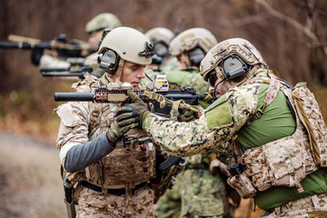 Instructor with soldier aiming machine gun at firing range.