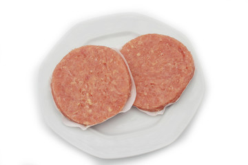 Raw fresh chicken burgers on a plate isolated on white background

