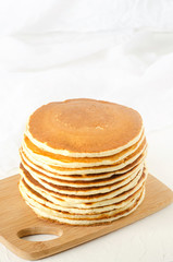 stack of pancakes on a yellow plate with honey