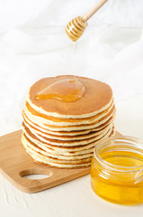 stack of pancakes on a yellow plate with honey