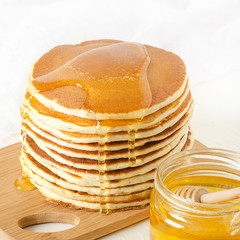 stack of pancakes on a yellow plate with honey