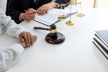 Fototapeta na wymiar Close up of gavel, Male lawyer or judge Consult with client and working with Law books, report the case on table in modern office, Law and justice concept