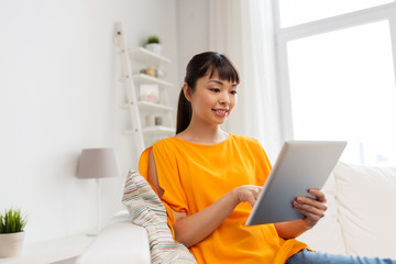 happy young asian woman with tablet pc at home