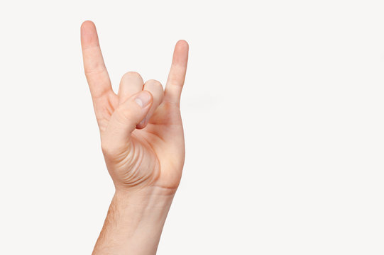 Closeup male rocker metal concert sign hand isolated on white background. Closeup expression fan gesture. Teen modern rock music symbol.