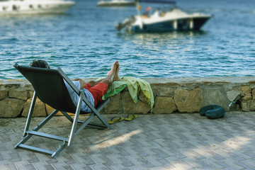 Fototapeta premium sleeping man on the chaise on the embankment of the Spanish town of Magaluf