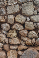 old stone wall of cobblestones of different sizes closeup