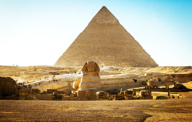 Egyptian sphinx with a ptramid in background - obrazy, fototapety, plakaty