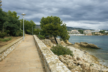 Fototapeta na wymiar a fragment of a beautiful promenade in the Spanish town of Magaluf on the background of the sea, the city and cloudy sky