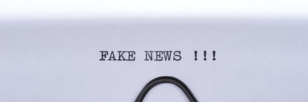 Black text Fake News written on white paper