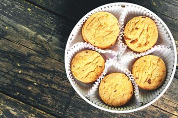 Round biscuits in a round box on a wooden background