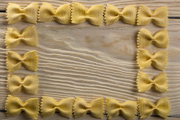 A frame of butterfly pasta on a wooden background
