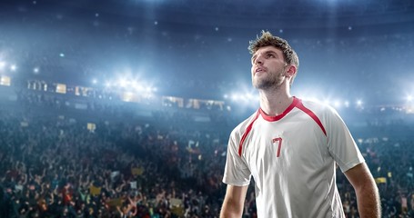 Happy soccer player on a football stadium