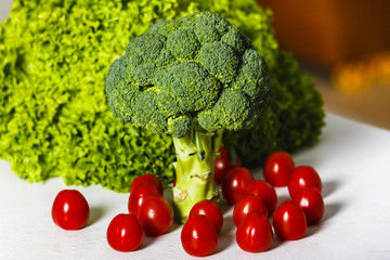 broccoli, green lettuce and cherry tomatoes on a table