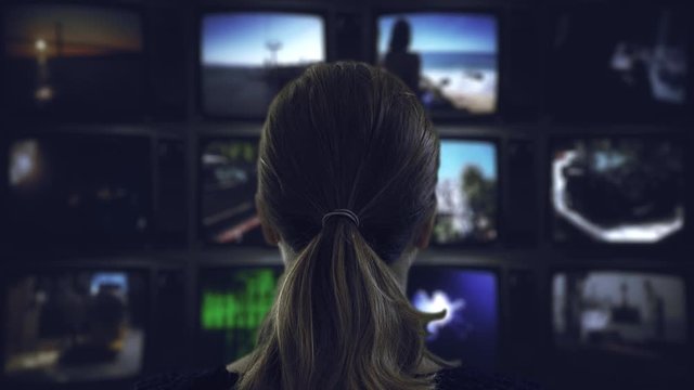Watching Tv Television Broadcast. Head shot of a ponytail woman watching many videos in a wall of televisions