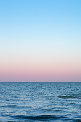 pink sky of sunset on the sea horizon, vertical composition.