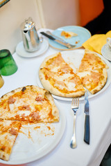 Delicious appetizing pizza with meat tomato cheese in a restaurant on the table