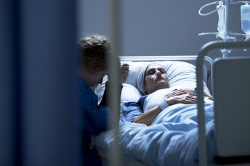 Worried mother supporting dying daughter