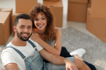 Young couple sitting on the floor in a new apartment