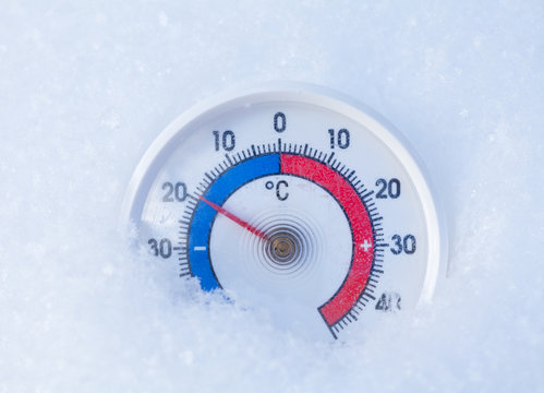Outdoor thermometer in snow shows minus 19 Celsius degree cold winter weather concept