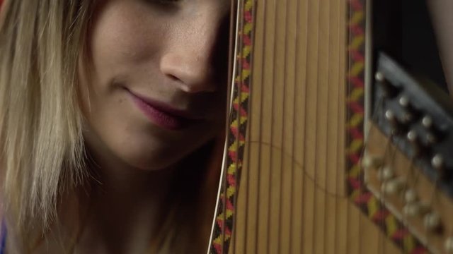The girl touches the nose of the bandura and smiles, refocus