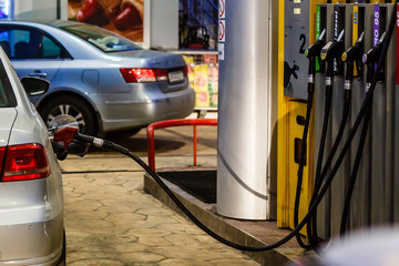 Fototapeta premium Car refueling on a petrol station at night closeup