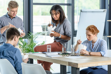 Business team eating chinese food in modern office