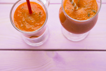 Fruit and Vegetable Smoothie, Healthy Food, Diet Concept. Two glasses of orange smoothie with carrot and pumpkin on pink wooden background
