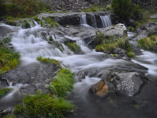 Detalle río en primavera a su paso entre piedras y brotes verdes en Extremadura