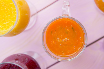 Fruit and Vegetable Smoothie, Healthy Food, Diet Concept. Pink wooden background with glasses of fruit, vegetable and berry smoothie, copy space, top view