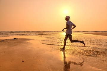 Fototapeta na wymiar Young man training on the beach in morning. 