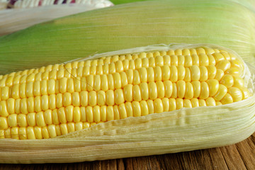 Fresh corn on the old wooden background