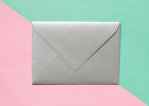 Silver envelope on pink background.