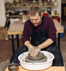 Artist makes clay pottery on a spin wheel