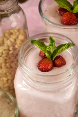 Protein cocktail with strawberries and mint in a glass jar