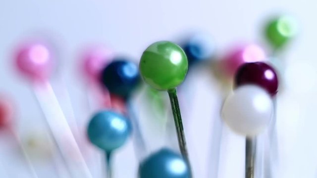 Tools tailor. Many multi-colored pins close-up. Shallow depth of field. Smooth rotation and impact.