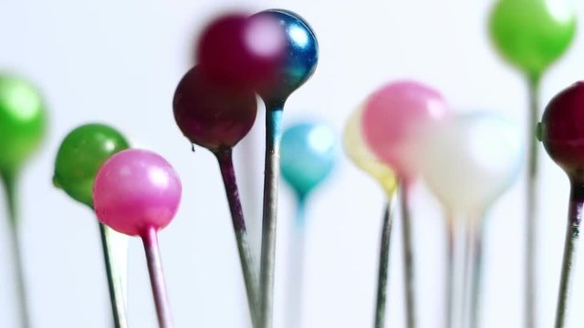 Tools tailor. Many multi-colored pins close-up. Shallow depth of field. Smooth rotation and impact.