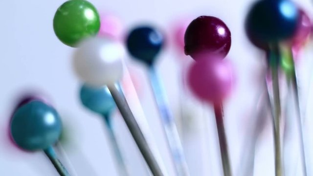 Tools tailor. Many multi-colored pins close-up. Shallow depth of field. Smooth rotation and impact.