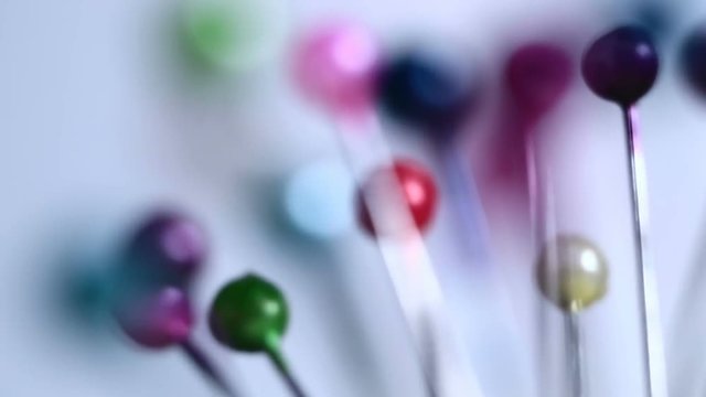 Tools tailor. Many multi-colored pins close-up. Shallow depth of field. Smooth rotation and impact.