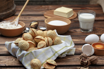 Fototapeta na wymiar homemade cookies shaped nuts with cream boiled condensed milk on wooden table. Rustic style