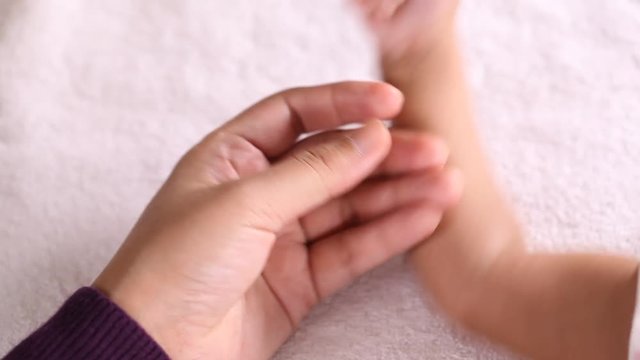 Mother holding baby's hand close up