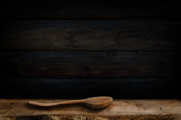 Wooden spoon isolated on background. Black wall background. Ukrainian rural style.